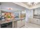 Bright kitchen featuring granite counters, white cabinetry and stainless dishwasher with an open view to the living room at 4475 Harmony Ct, Las Vegas, NV 89121