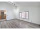 Bright living room featuring gray wood-look flooring, neutral walls, and a window with shutter style blinds at 4475 Harmony Ct, Las Vegas, NV 89121