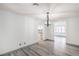 Spacious living room with gray wood-look flooring, neutral walls, and a view into the kitchen at 4475 Harmony Ct, Las Vegas, NV 89121