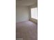 Empty room with beige carpet and large window offering natural light at 4760 Woodridge Rd, Las Vegas, NV 89121