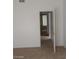 A simple bedroom with beige carpeting, window, and a doorway to another room at 4760 Woodridge Rd, Las Vegas, NV 89121
