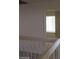 Upper level hallway with white banister and a view into a room with a window at 4760 Woodridge Rd, Las Vegas, NV 89121