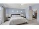 Cozy bedroom featuring a queen-size bed, light blue walls, and access to an ensuite bathroom at 482 Painted Sage Ct, Henderson, NV 89015
