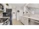 Bright kitchen with white cabinets, stainless steel appliances, and a view of the entry and stairs at 482 Painted Sage Ct, Henderson, NV 89015