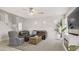 Spacious living room with neutral tones, a ceiling fan, a fireplace, and a view of the staircase at 482 Painted Sage Ct, Henderson, NV 89015