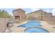 Backyard view of a kidney-shaped pool and outdoor seating area with wrought iron fence and light-colored stucco homes at 482 Painted Sage Ct, Henderson, NV 89015