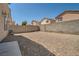Backyard showcasing gravel landscaping, block wall fence, and clear blue sky at 4832 Englewood Ave, Las Vegas, NV 89139