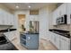 Well-lit kitchen with a center island, stainless steel refrigerator, and ample cabinet space at 4845 Santo Romeo St, Las Vegas, NV 89135