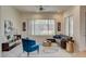 Comfortable living room featuring a ceiling fan, modern decor, and a large window overlooking the backyard at 4845 Santo Romeo St, Las Vegas, NV 89135