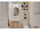 Clean powder room featuring a pedestal sink, decorative mirror, and neutral color palette at 4845 Santo Romeo St, Las Vegas, NV 89135