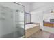 Bright bathroom featuring a glass-enclosed shower and a luxurious soaking tub at 4871 La Princesa Ct, North Las Vegas, NV 89031