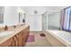 Bathroom featuring a double vanity, soaking tub, and walk-in shower at 4871 La Princesa Ct, North Las Vegas, NV 89031