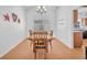 Inviting dining room with a wooden table, white walls, and hardwood-style flooring illuminated by a chandelier at 4871 La Princesa Ct, North Las Vegas, NV 89031