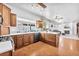 Open kitchen with wood cabinets, stainless appliances, and an island with adjacent living space at 4871 La Princesa Ct, North Las Vegas, NV 89031