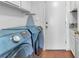Bright laundry room with blue washer and dryer, and ironing board at 4871 La Princesa Ct, North Las Vegas, NV 89031