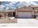 Inviting single-story house with two-car garage and desert landscaping at 5043 Naff Ridge Dr, Las Vegas, NV 89131