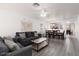 Open-concept living room with dining and kitchen area, gray sofas, and wood-look floors at 5043 Naff Ridge Dr, Las Vegas, NV 89131