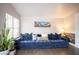 Spacious living room with a plush blue sofa, large window, and a scenic wall art at 520 Arrowhead Trl # 1322, Henderson, NV 89015