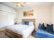 Comfortable main bedroom with a queen-size bed, accent wall art, and a comfortable blue sitting couch at 520 Arrowhead Trl # 1322, Henderson, NV 89015