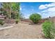 Backyard features a retaining wall, desert landscaping, and green bushes at 542 Grimsby Ave, Henderson, NV 89014