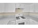 Close up of bright kitchen features white cabinets, appliances and speckled countertops at 542 Grimsby Ave, Henderson, NV 89014
