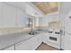 Bright kitchen features white cabinets, appliances and speckled countertops at 542 Grimsby Ave, Henderson, NV 89014
