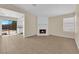 Bright living room with tile flooring, a white brick fireplace, and sliding glass doors to the backyard at 542 Grimsby Ave, Henderson, NV 89014
