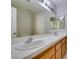 Bathroom with double sinks, white tile countertop, and a large mirror at 5424 Comchec Way # 105, Las Vegas, NV 89108