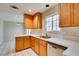 Well-lit kitchen featuring wooden cabinets, countertops, stainless steel dishwasher, and a window at 5424 Comchec Way # 105, Las Vegas, NV 89108