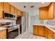 Modern kitchen equipped with stainless steel appliances, wooden cabinetry, and tile flooring offers an inviting space at 5424 Comchec Way # 105, Las Vegas, NV 89108