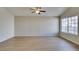 Spacious living room featuring luxury vinyl plank flooring, a ceiling fan, and large window providing ample natural light at 5424 Comchec Way # 105, Las Vegas, NV 89108