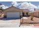 Inviting single-story home showcasing a two-car garage, desert landscaping, and a charming covered porch at 5528 Morningcross St, Las Vegas, NV 89130