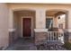 Charming front porch with brick accents, covered seating area, and a vibrant red entry door at 5528 Morningcross St, Las Vegas, NV 89130