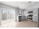 Well-lit kitchen features grey cabinets, stainless appliances, and sliding glass doors to the backyard at 5528 Morningcross St, Las Vegas, NV 89130