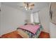 Cozy bedroom with wood floors, ceiling fan, and natural light from a window at 5548 Spearfish Lake Ct, Las Vegas, NV 89148