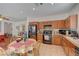 Eat-in kitchen boasts warm wood cabinetry, black appliances, and a tile floor at 5548 Spearfish Lake Ct, Las Vegas, NV 89148