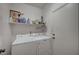 Functional laundry room with a washer, dryer, and storage shelf at 5548 Spearfish Lake Ct, Las Vegas, NV 89148