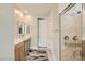 Bright bathroom featuring double sinks, stone countertops, and a glass-enclosed shower at 6432 Linden St, North Las Vegas, NV 89086