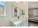 Bathroom with a double vanity featuring stone countertops and a view to the bedroom at 6432 Linden St, North Las Vegas, NV 89086