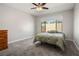 Comfortable bedroom with a ceiling fan, carpet flooring, a wooden dresser, and natural light at 6432 Linden St, North Las Vegas, NV 89086