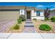 Inviting single-story home featuring a beautifully landscaped front yard with stone walkway to the front door at 6432 Linden St, North Las Vegas, NV 89086