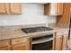 Modern kitchen featuring granite countertops, stainless steel oven, and light wood cabinetry at 6432 Linden St, North Las Vegas, NV 89086