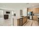 Stylish kitchen with a central island overlooking the living area and stainless steel appliances at 6432 Linden St, North Las Vegas, NV 89086