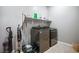 Laundry room equipped with stainless steel washer and dryer and ample storage shelving at 6432 Linden St, North Las Vegas, NV 89086