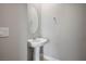 Clean powder room featuring a pedestal sink, oval mirror, and new hardware at 6432 Linden St, North Las Vegas, NV 89086