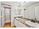 Bathroom featuring dual sinks, marble countertop, large mirror and tiled floor at 6747 Gold Yarrow St, Las Vegas, NV 89148
