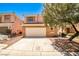 Two-story tan home with a two-car garage and desert landscaping in front at 6747 Gold Yarrow St, Las Vegas, NV 89148