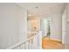 Upstairs hallway featuring laminate flooring and neutral paint with laundry hookups and bathroom access for convenience at 6747 Gold Yarrow St, Las Vegas, NV 89148