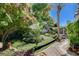 Beautiful backyard featuring a manicured lawn, mature trees, and a charming patio area at 7109 Deepriver Cir, Las Vegas, NV 89129