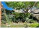 Landscaped backyard featuring a pond, lush greenery, mature trees, and colorful flowers for a tranquil outdoor space at 7109 Deepriver Cir, Las Vegas, NV 89129